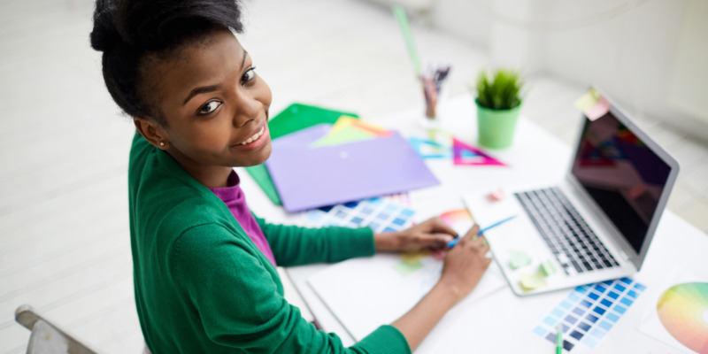 Creative fashion designer sitting by workplace